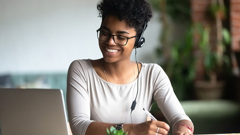 Black woman smiling and looking at laptop computer